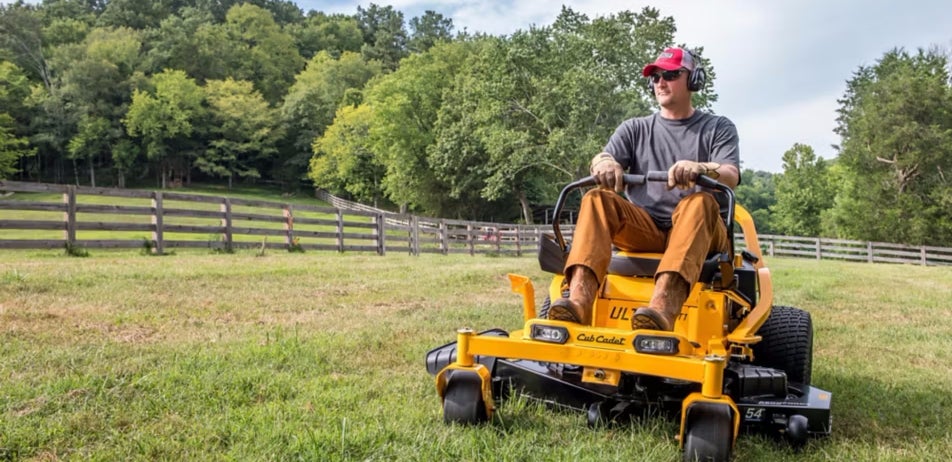 Man on a farm ranch riding a lawn mower