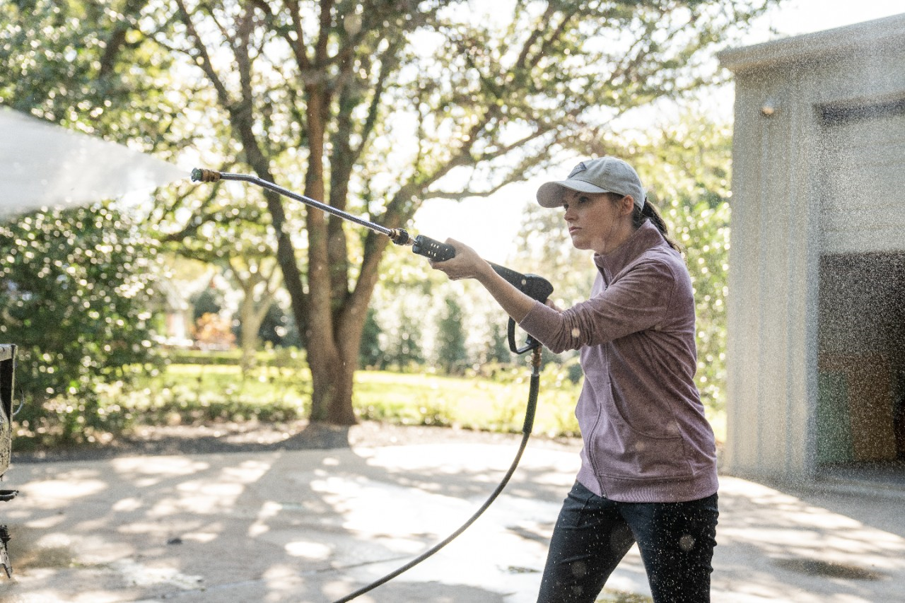 Image of a person using a pressure washer to clean.